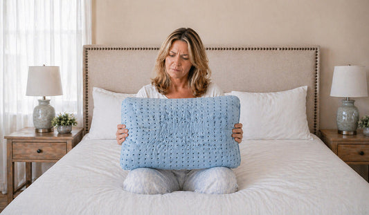 Woman holding a Low-quality cooling memory foam pillow and looking disappointed 