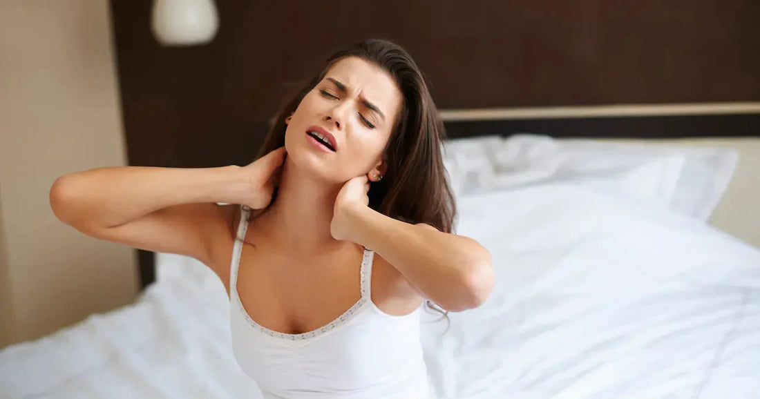 Woman in bed displaying discomfort from neck pain 