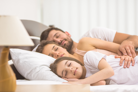 Mother, father and daughter sleeping peacefully as a family 